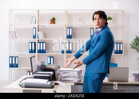 Junge Mitarbeiter von Kopien beim Kopieren von Maschine Stockfoto