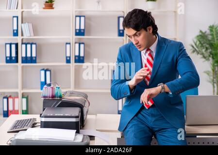 Junge Mitarbeiter von Kopien beim Kopieren von Maschine Stockfoto
