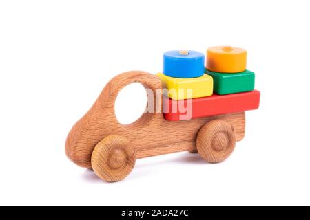 Close-up Spielzeug der Kinder der natürlichen Holz in Form einer Dump Truck mit Holzblöcken in Form von multi-farbige geometrische Formen auf einem weißen Stockfoto