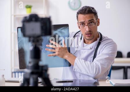 Junge männliche Arzt Radiologe Aufnahme von Video für seinen Blog Stockfoto