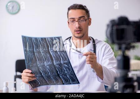 Junge männliche Arzt Radiologe Aufnahme von Video für seinen Blog Stockfoto