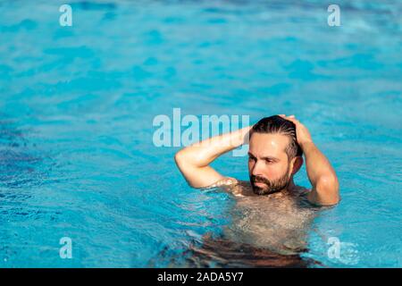Der Mensch ist das Schwimmen im Pool mit Spray auf dem Gesicht mit dramatischen Auswirkungen. Rest - Konzept. Stockfoto