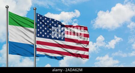 Sierra Leone und United Fahne im Wind gegen Weiße bewölkt blauer Himmel zusammen. Diplomatie Konzept, internationale Beziehungen. Stockfoto