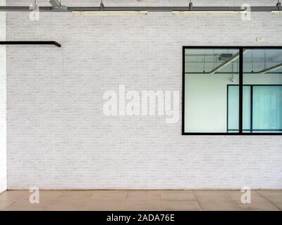 Weiße Mauer Hintergrund in der Nähe der Glasfenster im leeren Raum. Leerstelle auf Mauer loft Stil eingerichtet. Stockfoto