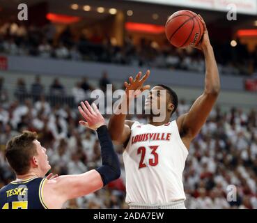 Louisville, USA. 03 Dez, 2019. Louisville Kardinäle Steven Enoch (23) Kämpfe zu bekommen sein Schuß weg unter Druck von Michigan Wolverines Jon Teske (15) während der ersten Hälfte des Spiels an KFY Yum! Zentrum in Louisville, Kentucky, 3. Dezember 2019. Foto von John Sommers II/UPI Quelle: UPI/Alamy leben Nachrichten Stockfoto