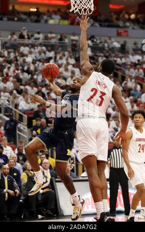 Louisville, USA. 03 Dez, 2019. Michigan Wolverine Zavier Simpson (3) kämpft um seinen Schuß weg unter Druck von Louisville Kardinäle Steven Enoch (23) während der ersten Hälfte des Spiels an KFY Yum! Zentrum in Louisville, Kentucky, 3. Dezember 2019. Foto von John Sommers II/UPI Quelle: UPI/Alamy leben Nachrichten Stockfoto