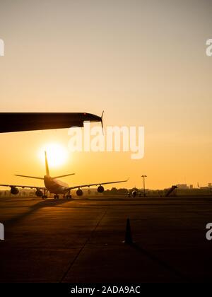 Bangkok, Thailand - 16. November 2019: Commercial Airplane Parkplätze am Sonnenuntergang in Don Muang Airport Bangkok, Thailand vertikale Stil. Stockfoto