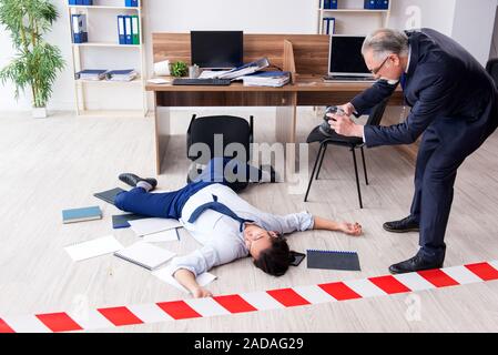 Forensische Ermittler und tote Mitarbeiter im Büro Stockfoto