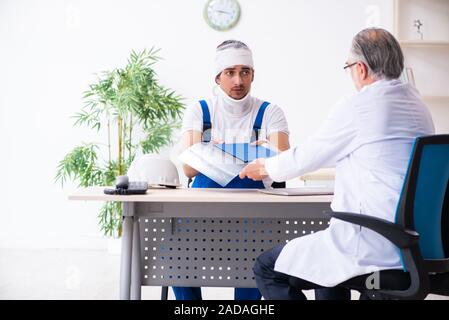Junge männliche Auftragnehmer alte Arzt Stockfoto
