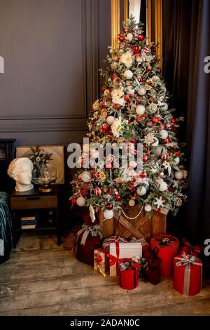 Schöne Ferienwohnung Zimmer dekoriert mit Weihnachtsbaum mit Geschenken unter ihm Stockfoto