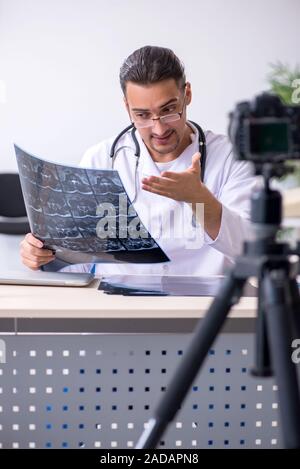 Junge männliche Arzt Radiologe Aufnahme von Video für seinen Blog Stockfoto