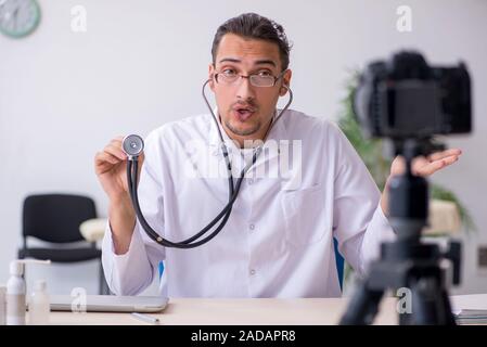 Junge männliche Arzt Aufnehmen von Video für seinen Blog Stockfoto