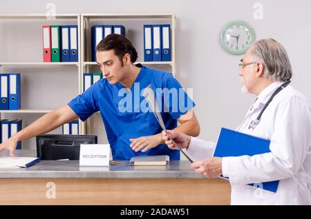 Zwei Ärzte im Gespräch an der Rezeption im Krankenhaus Stockfoto