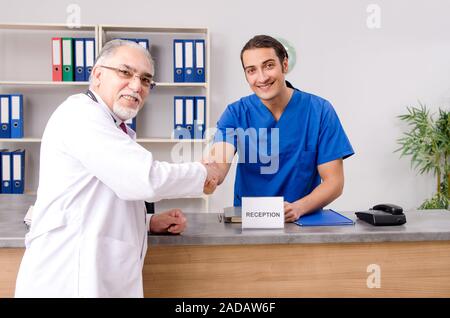 Zwei Ärzte im Gespräch an der Rezeption im Krankenhaus Stockfoto