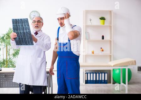 Junge männliche Auftragnehmer alte Arzt Stockfoto