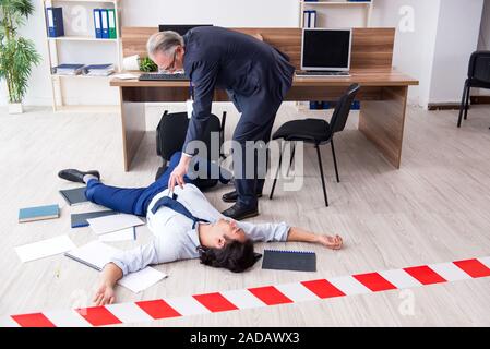 Forensische Ermittler und tote Mitarbeiter im Büro Stockfoto