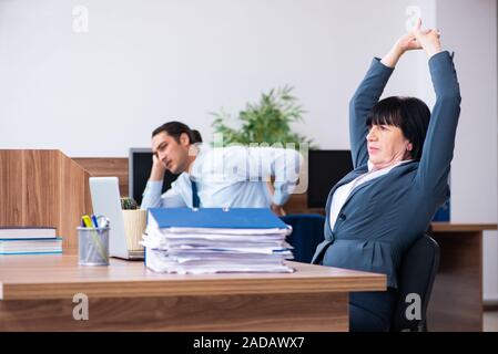 Zwei Mitarbeiter, die sportliche Übungen im Büro Stockfoto
