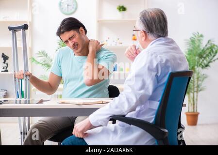 Junge Bein verletzt männlicher Patient alte Arzt Stockfoto