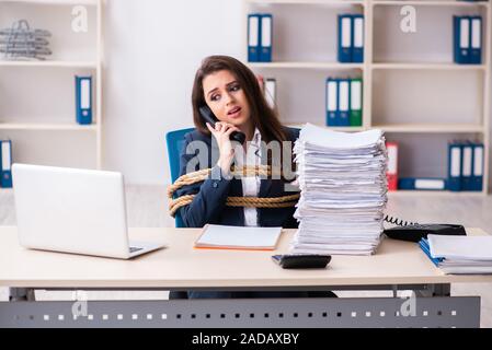 Junge schöne Mitarbeiter gebunden mit Seil im Büro Stockfoto