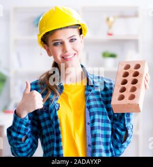 Frau mit Ziegel in der Bauwirtschaft Konzept Stockfoto