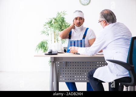 Junge männliche Auftragnehmer alte Arzt Stockfoto