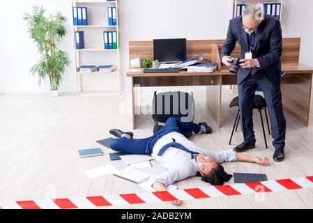 Forensische Ermittler und tote Mitarbeiter im Büro Stockfoto