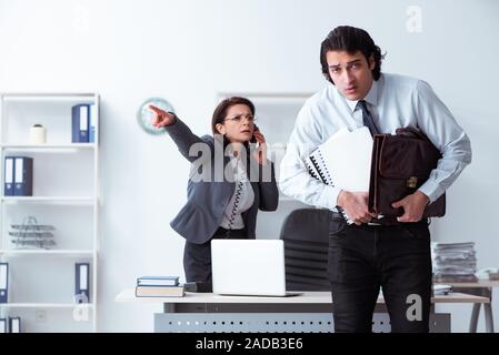 Alte Frau Boss und junge männliche Mitarbeiter im Büro Stockfoto