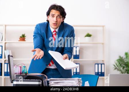 Junge Mitarbeiter von Kopien beim Kopieren von Maschine Stockfoto