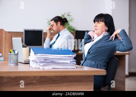 Zwei Mitarbeiter, die sportliche Übungen im Büro Stockfoto