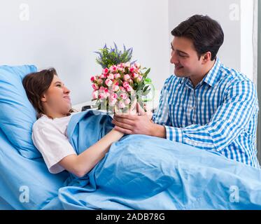 Pflege liebevoller Ehemann besuchen schwangere Frau im Krankenhaus Stockfoto