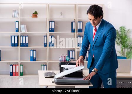 Junge Mitarbeiter von Kopien beim Kopieren von Maschine Stockfoto