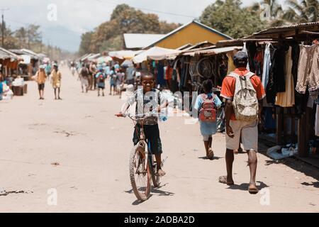 Madagaskar Oktober 18.2016 glücklich und lächelnd Junge Reiten Fahrrad auf der Main Street. Maroantsetra Oktober 18. 2016, Madagaskar. Stockfoto