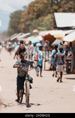 Madagaskar Oktober 18.2016 glücklich und lächelnd Junge Reiten Fahrrad auf der Main Street. Maroantsetra Oktober 18. 2016, Madagaskar. Stockfoto