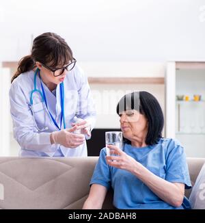 Junger Arzt besuchen alte reife Frau für Check-up Stockfoto