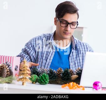 Junger Mann, der weihnachtsdekoration von Kegel Stockfoto