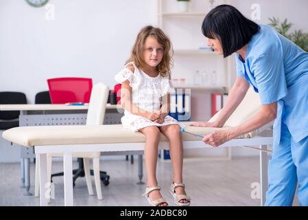 Kleines Mädchen besuchen alte Frau Doktor Stockfoto