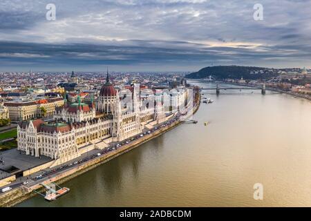 Budapest, Ungarn - Luftaufnahme des schönen Parlament Ungarns bei Sonnenuntergang mit Golden Lights und Sightseeing Boote auf dem Fluss Donau. Szechenyi C Stockfoto