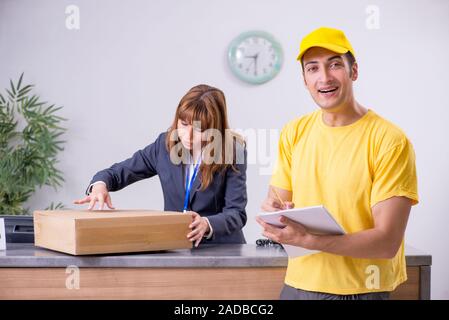 Junge männliche Kurier, Lieferung an der Rezeption Stockfoto
