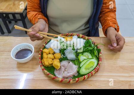 Frau mit Stäbchen Essen und Vietnamesischen traditionelle Küche, Bun Dau Stockfoto