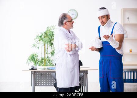 Junge männliche Auftragnehmer alte Arzt Stockfoto