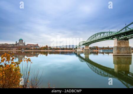 Esztergom, Ungarn - Herbst Blätter und Laub mit Maria-valeria-Brücke und der Basilika der Jungfrau Maria in Esztergom auf einem Morgen, übernommen von Stockfoto