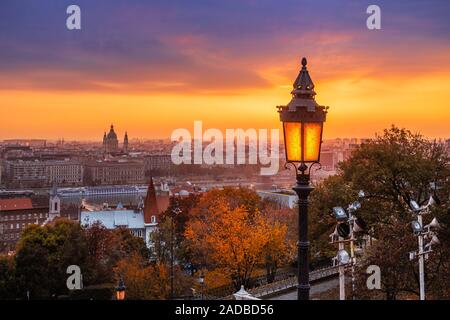 Budapest, Ungarn - Farbenfroher Herbstmorgen in Budapest. Straßenlaterne an der Fischerbastion, der Stephansbasilika und der wundervolle goldene Sonnenaufgang Stockfoto