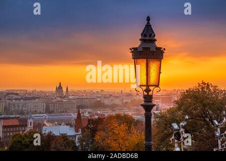 Budapest, Ungarn - Farbenfroher Herbstmorgen in Budapest. Straßenlaterne an der Fischerbastion, der Stephansbasilika und der wundervolle goldene Sonnenaufgang Stockfoto