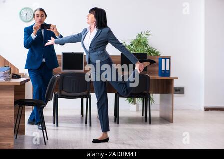 Zwei Mitarbeiter, die sportliche Übungen im Büro Stockfoto
