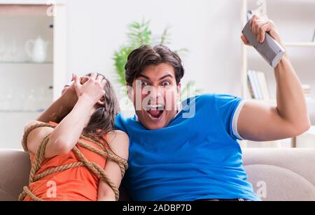 Mann binden bis seine Frau zur sportschau Fußball Stockfoto