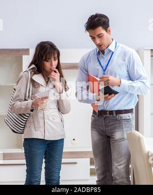 Der Verkäufer erklärt, Frau Kunde im Möbelhaus Stockfoto