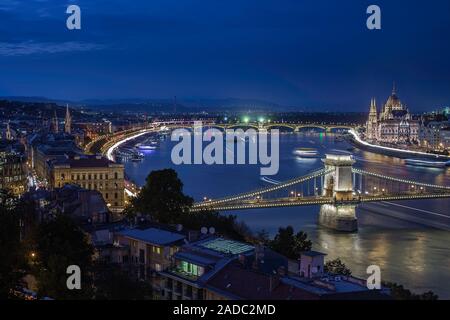 Budapest, Ungarn - beleuchtete Széchenyi Kettenbrücke auf eine Nacht Foto mit dem Parlament Ungarns, die Schiffe auf der Donau und klaren dunklen b Stockfoto