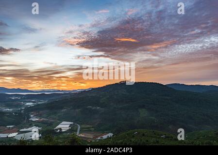 Das Tal und die Landschaft Häuser unter bedeckt orange sky bei Dämmerung Stockfoto