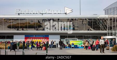 Eindhoven Niederlande. Oktober 14, 2019. Personen Gepäck vor Eindhoven Airport terminal Fassade, sonnigen Herbsttag Stockfoto