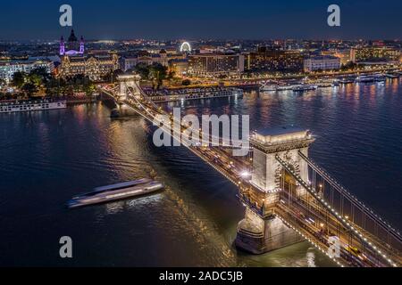 Budapest, Ungarn - Luftbild Drohne einen wunderschönen Blick auf den beleuchteten Széchenyi Kettenbrücke an einem schönen Sommerabend mit Schiff auf dem Fluss Danu Stockfoto